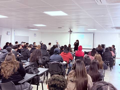 Una charla motivacional en una sala llena de estudiantes atentos.