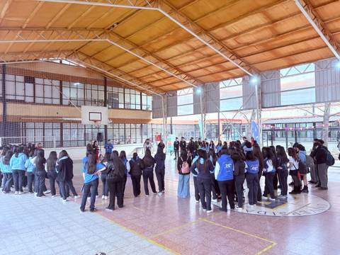 Un grupo de estudiantes se organiza en un gimnasio escolar para una actividad.