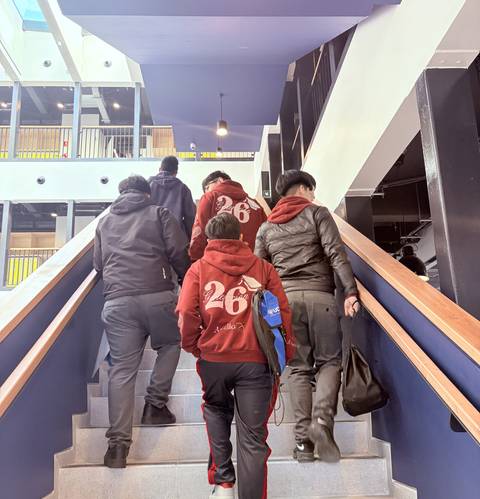 Un grupo de jóvenes subiendo por una escalera en un edificio moderno.