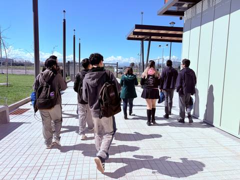 Un grupo de estudiantes camina por una vereda en un día soleado.
