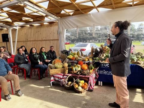 En una actividad con hortalizas, un ponente comparte conocimientos mientras una audiencia atenta observa.