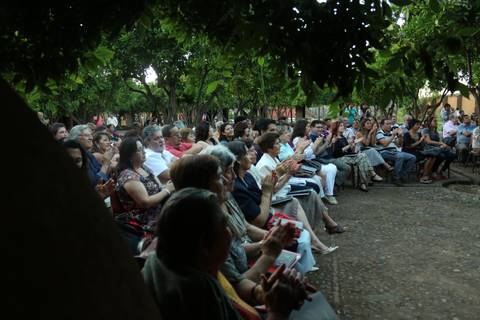 Un público entusiasta aplaude durante un evento al aire libre.