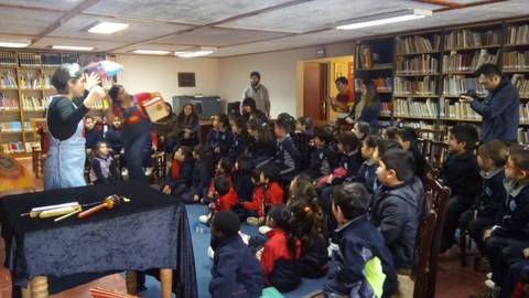 Una narradora de cuentos entretiene a un grupo de niños en una biblioteca.