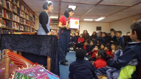 Un cuento está siendo narrado a un grupo de niños en una biblioteca.