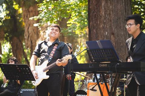 Una banda de música toca al aire libre en un entorno natural.
