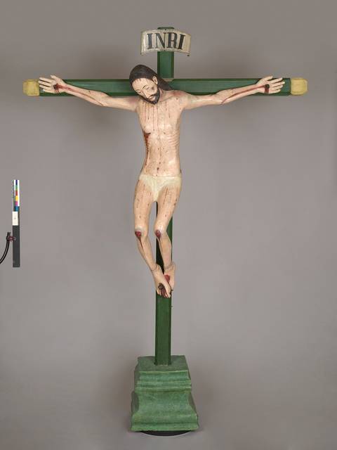 Una escultura de Cristo crucificado sobre una cruz con la inscripción INRI.