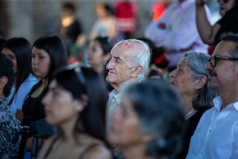 Un grupo de personas de diferentes edades escuchando atentamente un evento.
