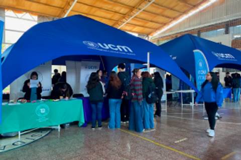 Una feria educativa en la que la gente interactúa bajo carpas de la UCM.