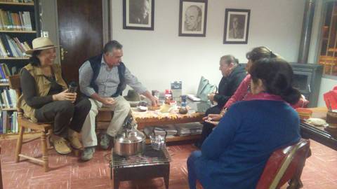 Un grupo de personas se reúne en una sala acogedora para compartir una comida y conversar.