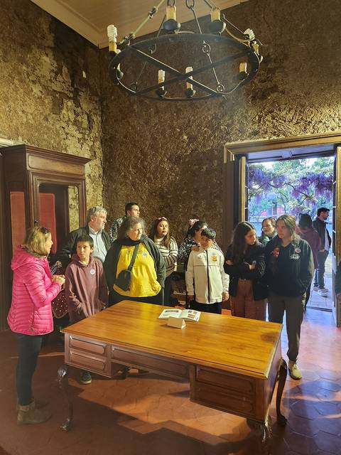 Grupo de personas en una habitación con un atractivo mobiliario antiguo.