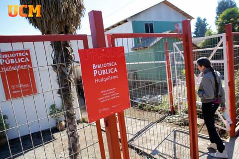 Una persona camina hacia la entrada de una biblioteca pública en un día soleado.