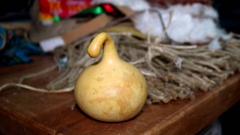Una calabaza amarilla con forma peculiar sobre una mesa de madera.