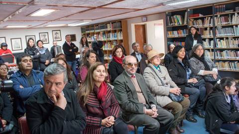 Un grupo de personas escuchando atentamente en una sala de biblioteca.