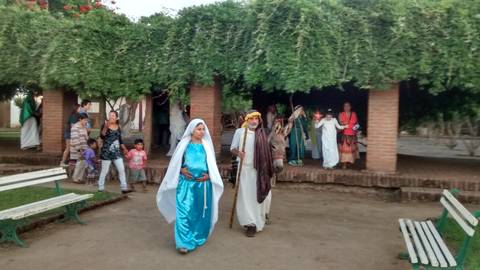 Un grupo de personas participa en una representación en un parque, vestidas con trajes tradicionales.