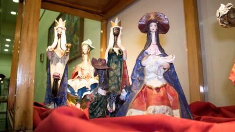 Un grupo de figuras tradicionales con vestimenta colorida expuestas en una vitrina.