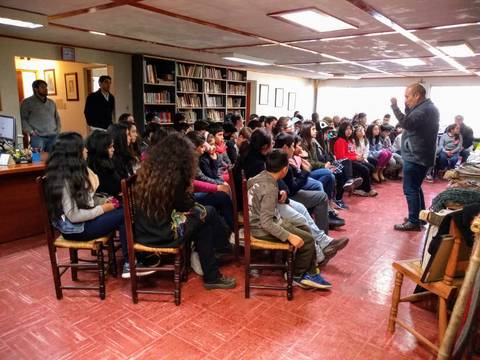 Un grupo de estudiantes escuchando atentamente a un orador en un salón.