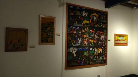 Sala de exhibición con varias obras de arte en las paredes.