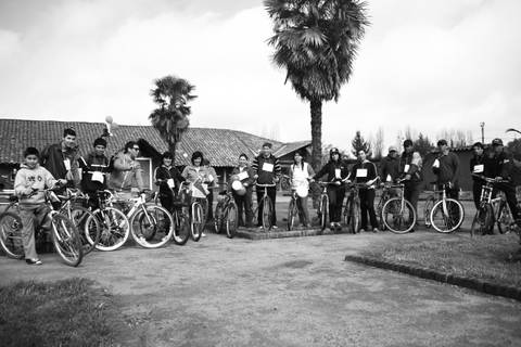 Un grupo de personas posando junto a sus bicicletas en un entorno al aire libre.