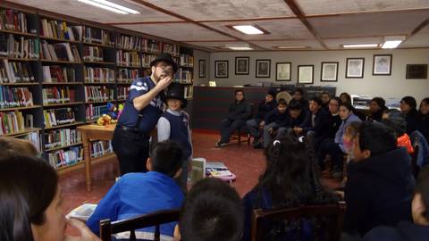 Un narrador cuenta historias a un grupo de niños en una biblioteca.