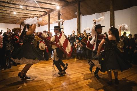 Un grupo de personas bailando en trajes tradicionales en un ambiente festivo.