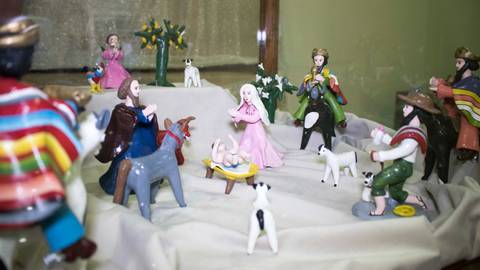 Una escena de un nacimiento, representada por figuras de cerámica en un pesebre con animales y personas vestidas con trajes tradicionales.