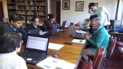 Un grupo de personas trabajando en sus computadoras en una sala de estudio.