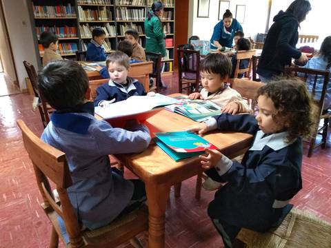 Un grupo de niños disfrutando de la lectura en una biblioteca.