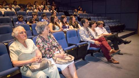Grupo de personas sentadas en un auditorio durante un evento.