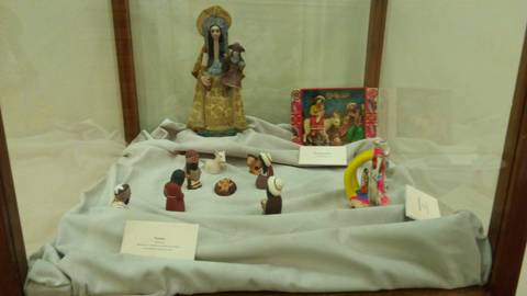 La imagen muestra un vitrina con figuras y esculturas de cerámica, representando escenas navideñas y personajes tradicionales.