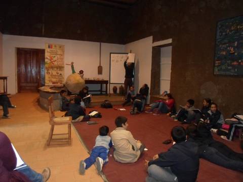 Un grupo de niños participan en una actividad educativa en un salón amplio.
