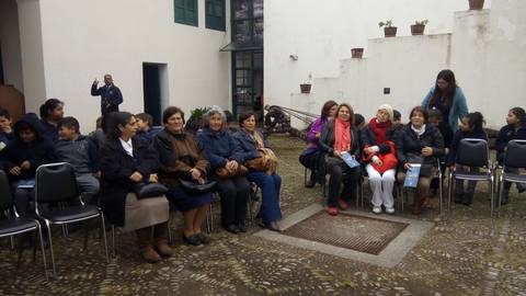 Un grupo de personas sentadas en sillas en un evento al aire libre.