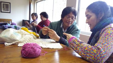 Un grupo de mujeres se reúne para tejer y compartir en un ambiente acogedor.