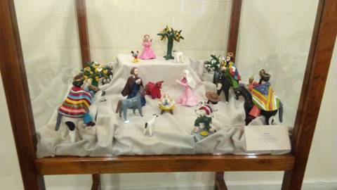 La imagen muestra un vitrina con figuras de cerámica representando escenas rurales y tradiciones folclóricas.