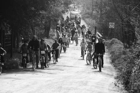 Un grupo de personas pedaleando en bicicletas por un camino rural.