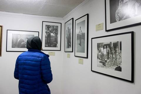 Una persona observa una exposición de fotografías en blanco y negro en una galería.
