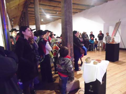 Un grupo de personas observa una presentación en un espacio cultural.