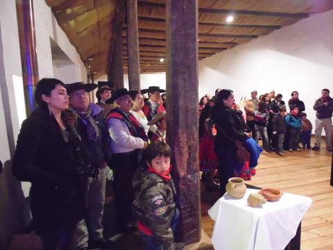 Un grupo de personas observando un evento en un ambiente rural con decoración tradicional.