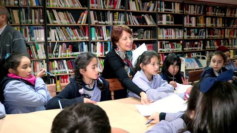 Un grupo de niños jóvenes participan en una actividad dentro de una biblioteca.