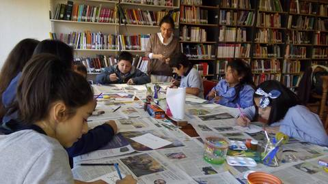 Un grupo de niños participa en una actividad creativa en una biblioteca.