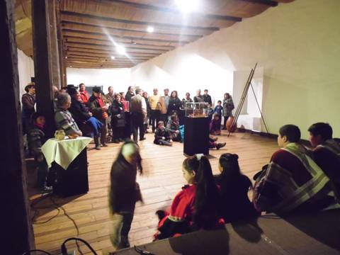 Un grupo de personas reunidas en un salón, participando en una actividad social o cultural.