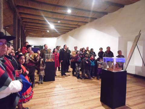 Una multitud de personas observa una exposición en un museo.