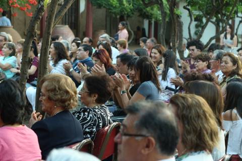 Un grupo de personas aplaudiendo en un evento al aire libre.