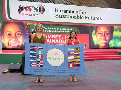 Mujeres sosteniendo una bandera en un evento internacional sobre desarrollo social en Nairobi.