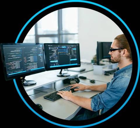 Un programador trabajando frente a dos monitores con código en pantalla.