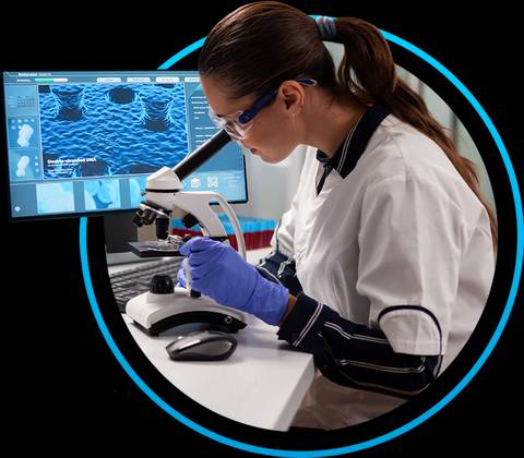 Una científica observa una muestra a través de un microscopio en un laboratorio.