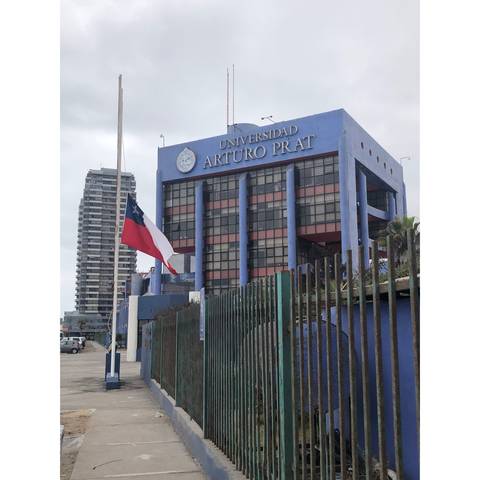 Edificio de la Universidad Arturo Prat bajo un cielo nublado en Iquique.