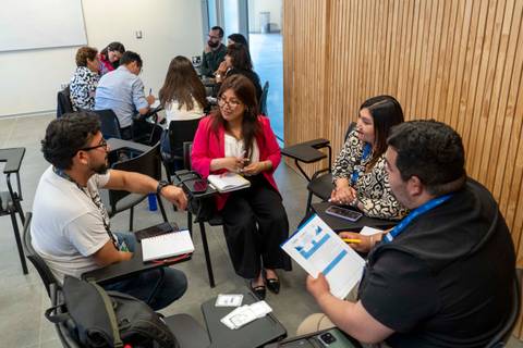 Un grupo de personas en una reunión colaborativa discutiendo ideas en un espacio moderno.
