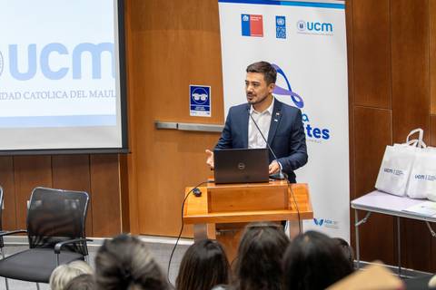 Un hombre presenta en una conferencia en la Universidad Católica del Maule.