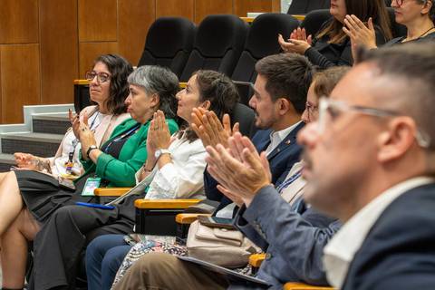 Un grupo de personas aplaudiendo en una presentación.