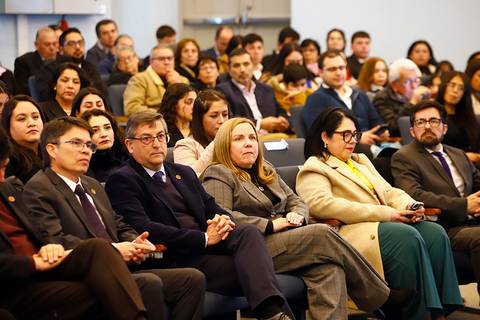 Un grupo de personas sentadas en un evento, mostrando interés en lo que ocurre en el escenario.